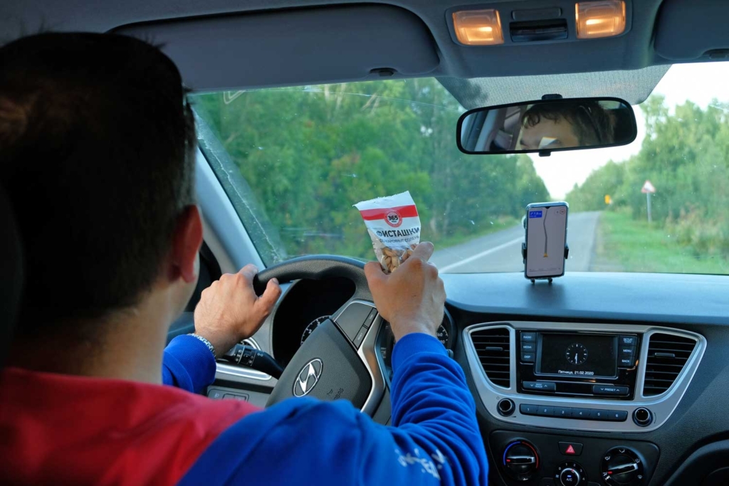 мужчина за рулем ест фисташки